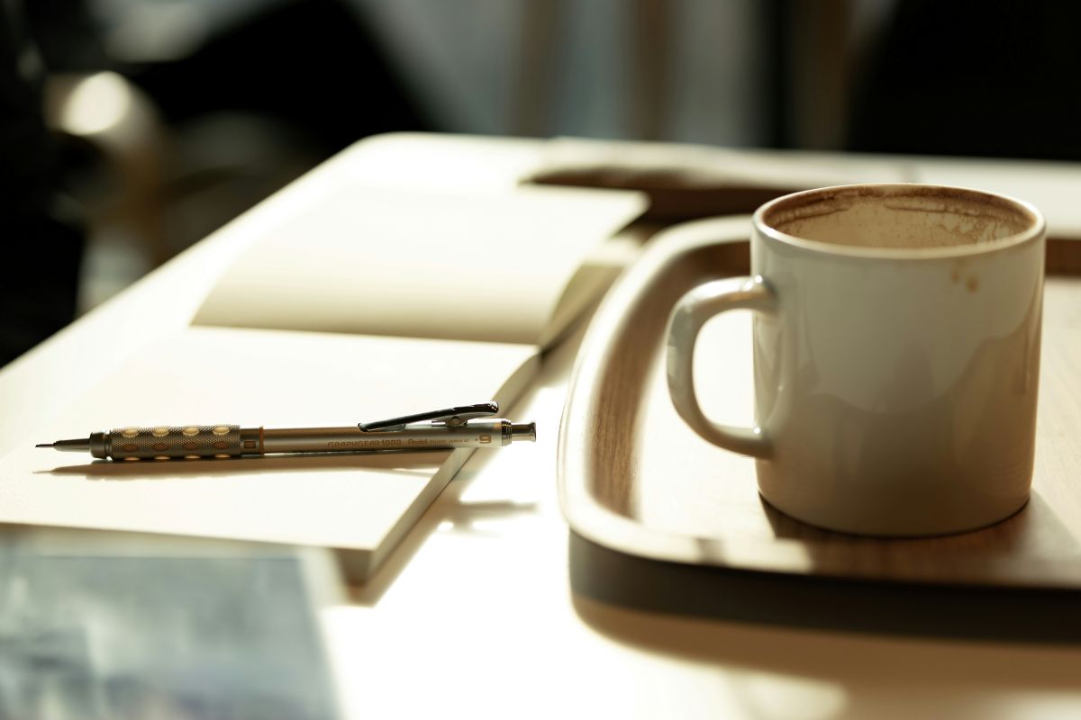 Notitieboek met pen en kop koffie op een tafel voor het plannen van doelen
